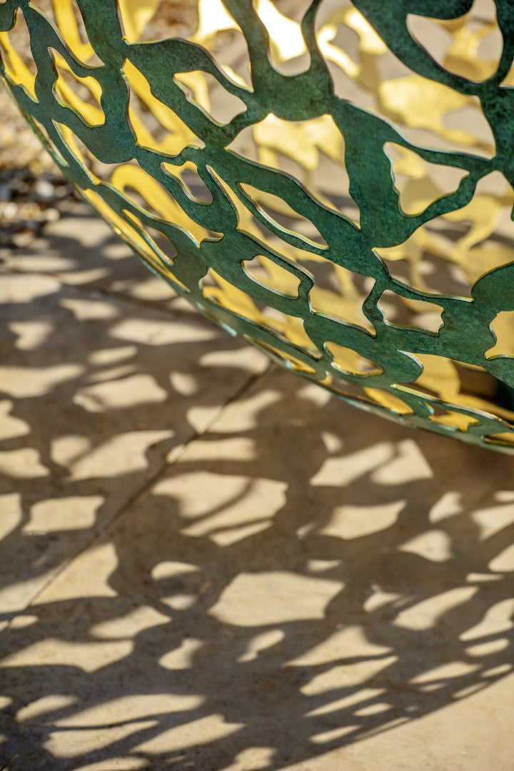 Close-up of a green and yellow metal fence with intricate patterns.